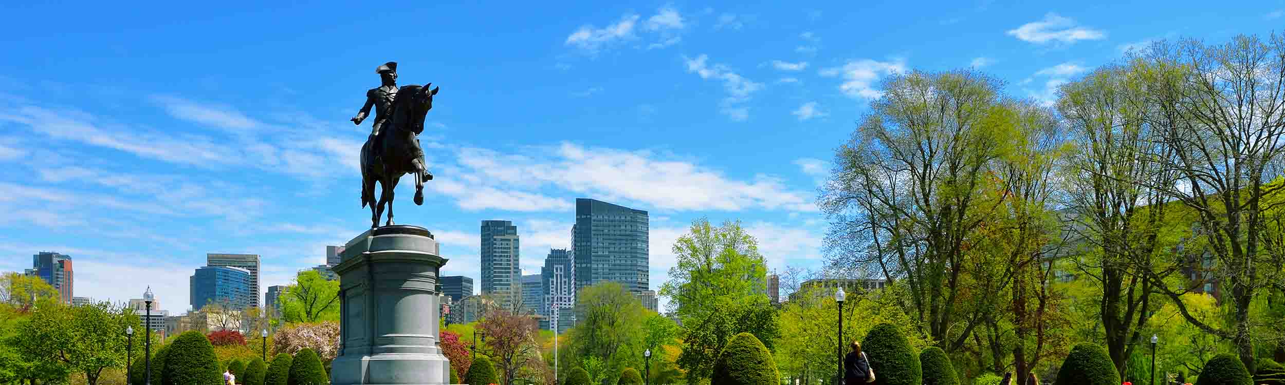 A panoramic view of the Public Garden in Boston, Massachusetts, featuring the iconic equestrian statue of George Washington.